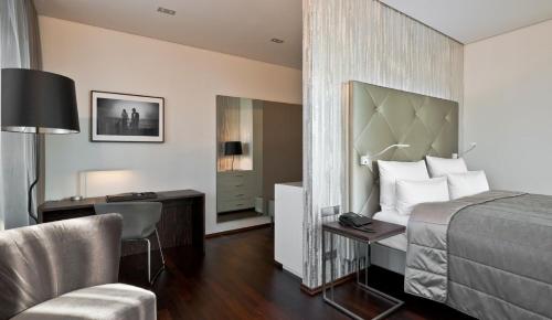 a hotel room with a bed and a desk and a chair at COSMO Hotel Berlin Mitte in Berlin