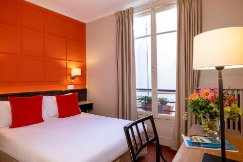een hotelkamer met een bed en een raam bij Hotel Clément in Parijs
