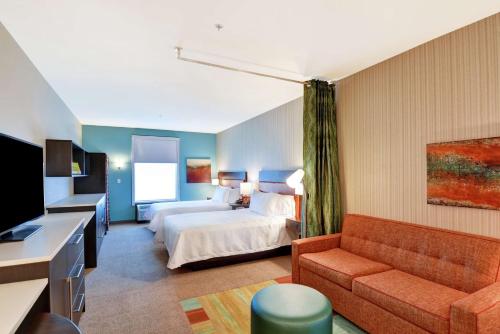 ein Hotelzimmer mit einem Bett und einer Couch in der Unterkunft Home2 Suites By Hilton Las Vegas Strip South in Las Vegas