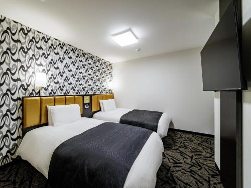 a hotel room with two beds and a wall at APA Hotel Nagasaki Dejima in Nagasaki