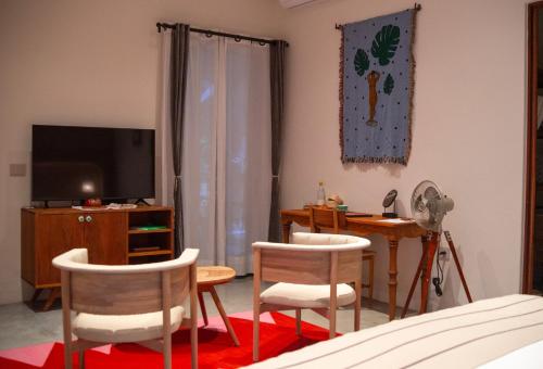 a living room with a table and chairs and a television at Casa Antonieta in Oaxaca City
