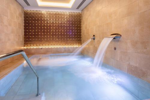 a hot tub with a water fountain in a bathroom at Catalonia Atocha in Madrid