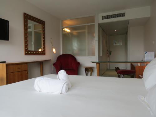 a room with a bed with a towel on a table at Hôtel Restaurant d'Occitanie in Toulouse