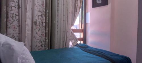 a bedroom with a window with a bed and a curtain at Quarto plutão in Duque de Caxias