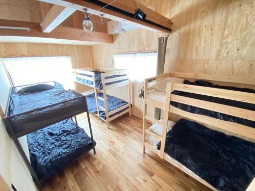 a room with two bunk beds and wooden floors at SNUG CAMP HOUSE - Vacation STAY 98114v in Okubo