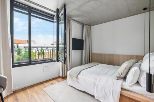 um quarto com uma cama e uma janela grande em Habyt-The Waterfront em Berlim