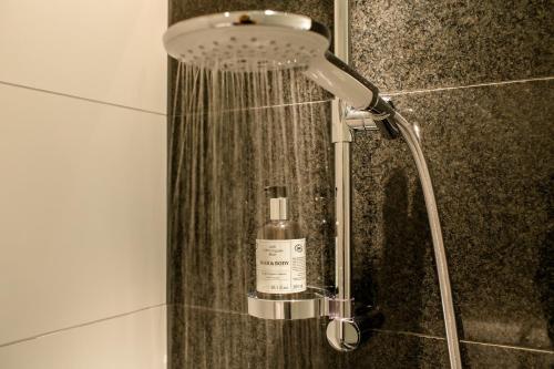 a shower in a bathroom with a bottle of soap at Motel One Berlin-Hauptbahnhof in Berlin