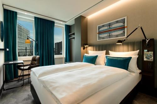 a hotel room with a large bed and a window at Motel One Berlin-Hauptbahnhof in Berlin