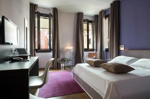- une chambre avec un lit, un bureau et des fenêtres dans l'établissement Corte Di Gabriela, à Venise