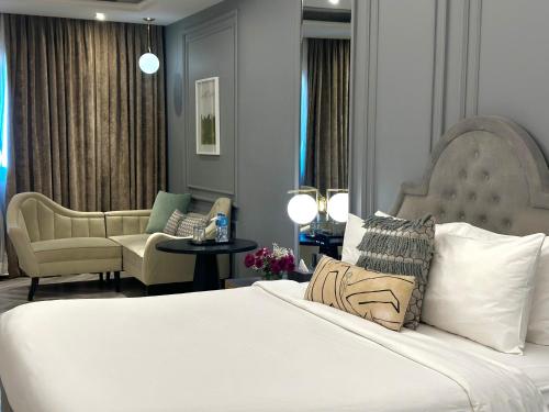 a bedroom with a bed and a living room at The Nishat Hotel Johar Town in Lahore