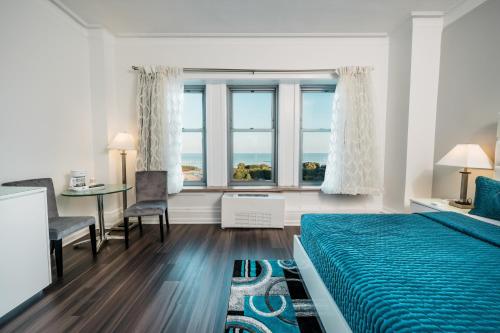 a bedroom with a blue bed and a table and chairs at Congress Plaza Hotel Chicago in Chicago