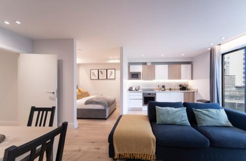 ein Wohnzimmer mit einem blauen Sofa und ein Schlafzimmer in der Unterkunft Palmer Apartments - Elephant & Castle in London