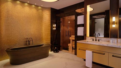 un bagno con una grande vasca e due lavandini di Hotel Taschenbergpalais Kempinski a Dresda