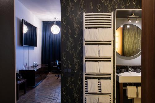 a bathroom with a towel rack with a sink and a mirror at Hotel Adele am Alex in Berlin