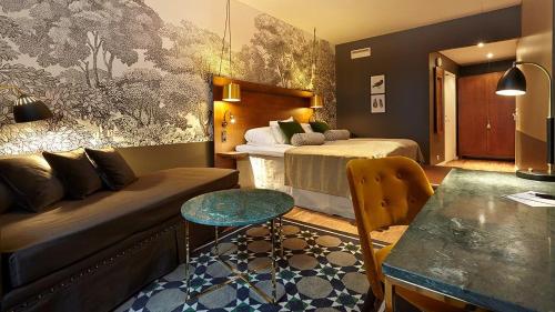 マルメにあるHome Hotel Temperanceのベッドとソファのあるホテルの部屋