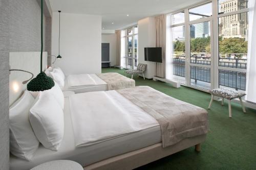 a hotel room with two beds and a flat screen tv at Hotel Metropol in Warsaw