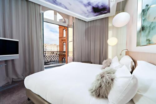 Rúm í herbergi á Le Grand Balcon Hotel